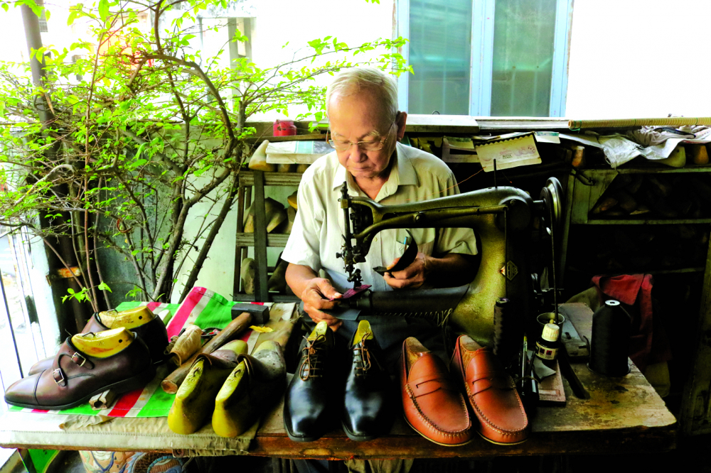  Nghệ nhân Trịnh Ngọc bên chiếc máy may có tuổi đời hơn nửa thế kỷ